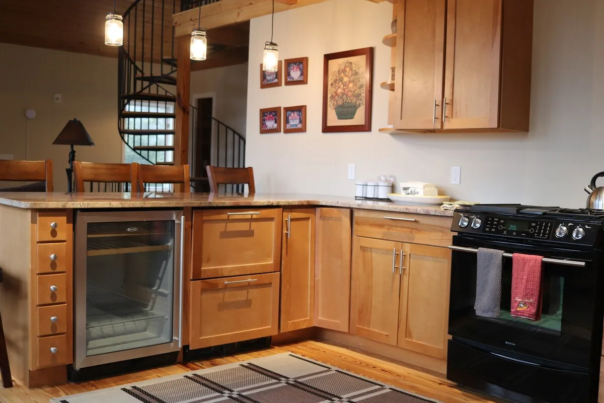 A welcoming kitchen with an island, refrigerator, stove, and decorative wall art. The space is filled with the warm ambiance of family gatherings and the promise of shared meals after a day on the slopes.